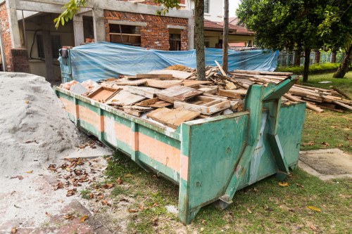 Construction site with builders waste being cleared in Honor Oak